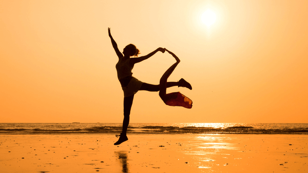 A woman dances at sunset, enjoying the movement