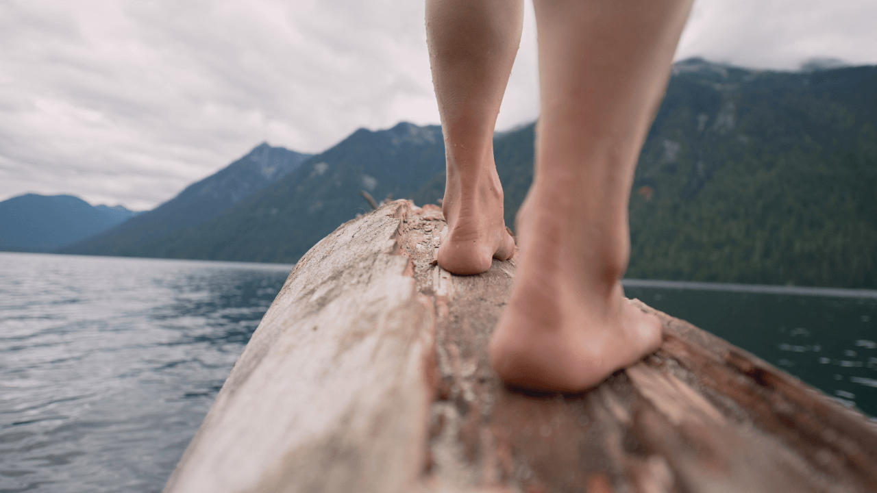 Ein Mann erdet sich auf einen Holzstamm in der Natur