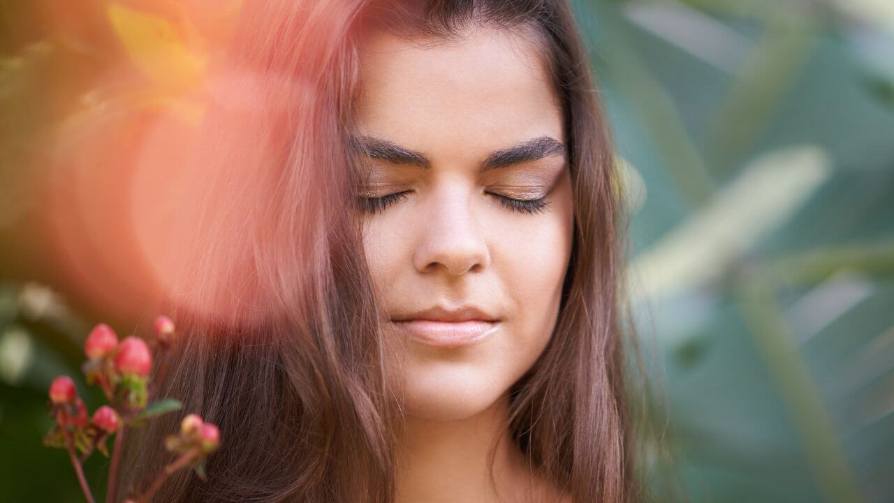 Frau mit geschlossenen Augen, die das Konzept von gesundem Inneren und gesundem Äußeren verkörpert.
