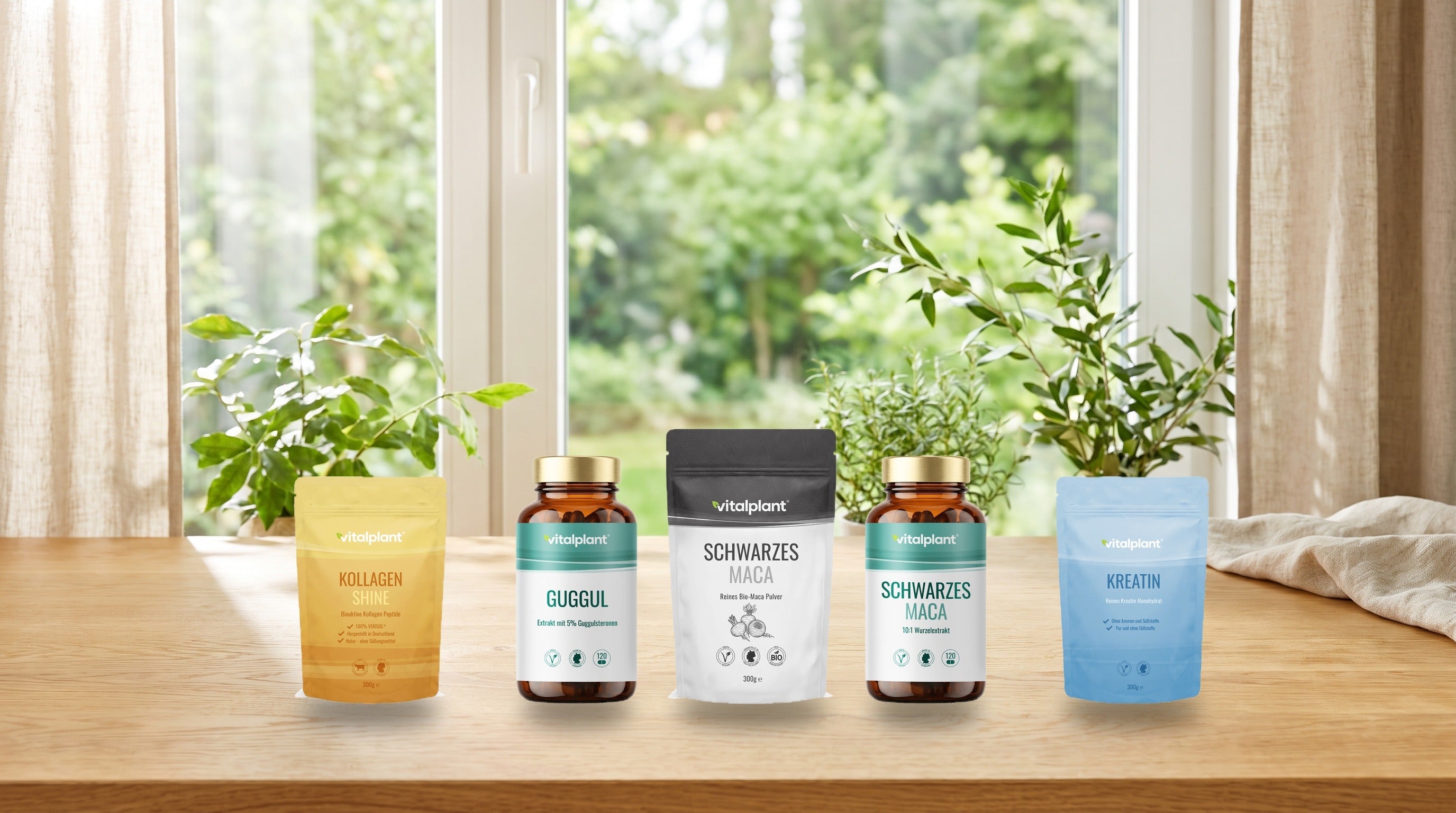 Fünf Vitalplant-Produkte auf einem Holztisch vor einem Fenster ins Grüne