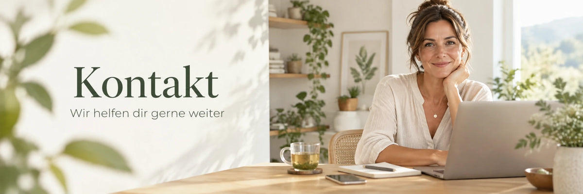 Kontakt – wir helfen dir gerne weiter. Frau am Schreibtisch mit Laptop, Zimmerpflanzen und einer Tasse Kräutertee