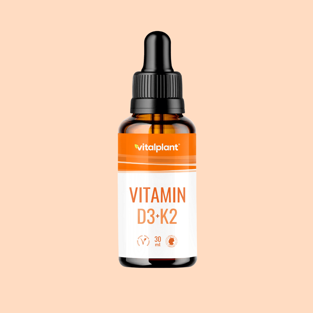Flasche mit Vitamin D3 + K2 Tropfen von Vitalplant mit 30 ml Inhalt auf orangefarbenem Hintergrund.